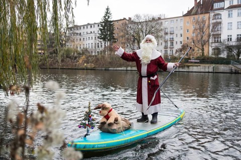 A water sports enthusiast dressed up as Santa Claus rides a SUP on the Spree in Berlin on 30.11