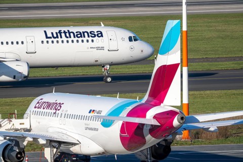 Lufthansa Airbus A321-200 on taxiway for takeoff, Eurowings Airbus parks outside position,