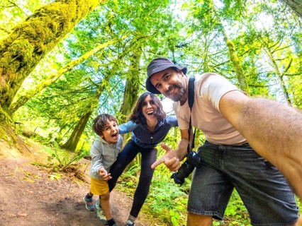 Happy family taking a selfie in the beautiful cathedral grove forest on vancouver island, british