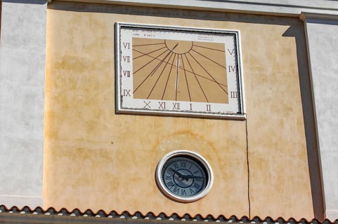 Sundial above and below masonry clock with hands, Italy
