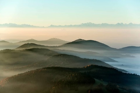View from Belchen heading south of Wiesental and the Swiss Alps, morning atmosphere with fog in