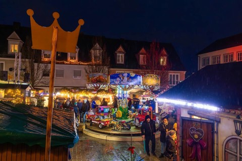 Overview of a Christmas market with crown, carousel and festive lighting at night, Böblingen