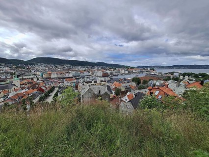 Panoramic view of Bergen city with hills in the background under a cloudy sky, Bergen Norway