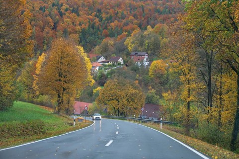Federal road leads through an autumnal mixed forest, Egloffstein, Upper Franconia, Bavaria, Germany