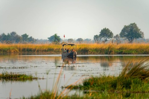 Tourist boat on safari in the lagoon, Xakanaxa Lagoon, Okavango Delta, Moremi Game Reserve,
