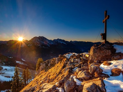 Summit cross of the board fork at sunset, in the back Watzmann, Hochkalter and Reiteralpe,