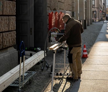 Craftsman with circular saw in the open air, Jägerstraße Berlin, Germany