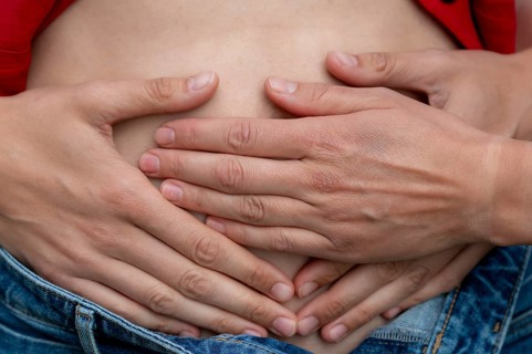 Symbolic picture of pregnancy, hands lying on a woman's stomach