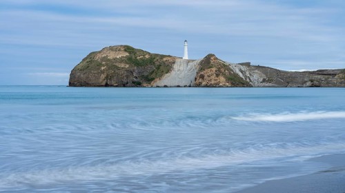 Castlepoint Beach with lighthouse on the rock, ocean, long exposure. Castlepoint, Wairarapa Coast,