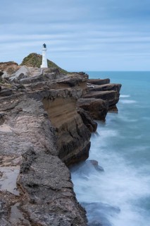 Castlepoint lighthouse on a rock, sea, long exposure. Castlepoint, Wairarapa Coast, Wellington