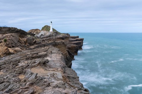 Castlepoint lighthouse on a rock, sea, long exposure. Castlepoint, Wairarapa Coast, Wellington