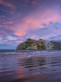 Castlepoint Beach, ocean and lighthouse on a rock, evening, sunset, dramatic sky. Castlepoint,