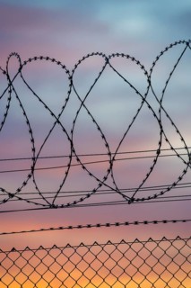 Braided barbed wire stands out against colorful evening sky, Baden-Württemberg, Germany