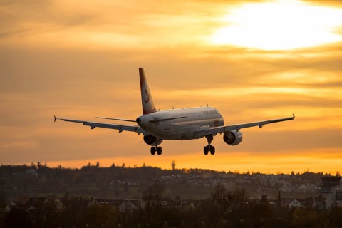 Airplane landing at sunset, orange light on horizon, Stuttgart airport, Leinfelden-Echterdingen,