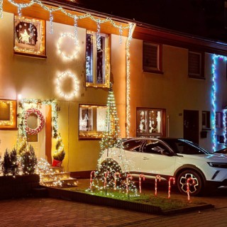Christmassy kitschy illuminated façade of a row house in Gelsenkirchen-Ückendorf in the evening,