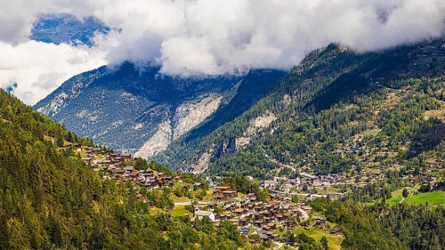 Rising fog in the Val d'Anniviers, below the mountain village of Saint-Jean, Valais Alps, Canton of