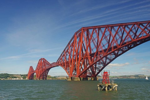A distinctive red bridge spanning a wide river under clear skies, railway bridge, Firth of Forth,