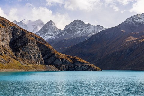 The turquoise Lac de Moiry reservoir, behind the peaks of the Grand Cornier, Tete Blanche and