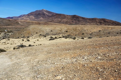 Wide, dry hilly landscape with a distant mountain under clear skies, Playa Blanca Lanzarote, Canary