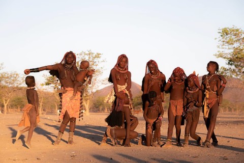 Group of Himba children and woman, evening mood, traditional Himba village, Kaokoveld, Kunene,
