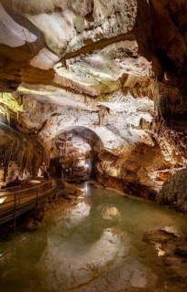 Stalactites and stalagmites, reflection in a small underground lake, rock formations in a