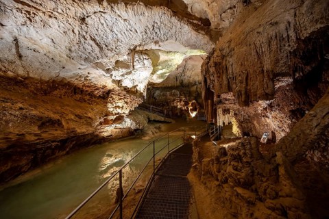 Stalactites and stalagmites, reflection in a small underground lake, rock formations in a
