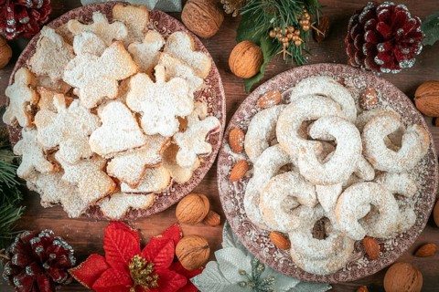 Vanilla croissants and Christmas cookies on two plates with festive decoration