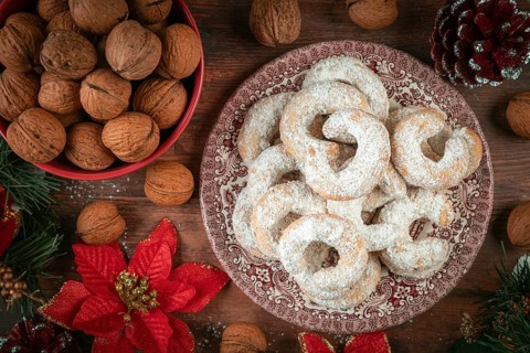Vanilla croissants on a plate next to walnuts and Christmas decoration
