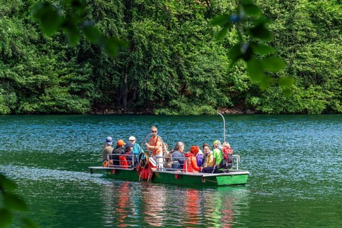 Manually operated ferry with ferryman and passengers, Lake Schmaler Luzin, Feldberg Lake District,