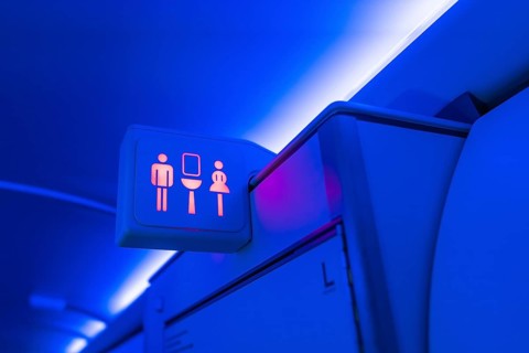 Illuminated restroom sign indicating availability with male and female symbols glowing red inside