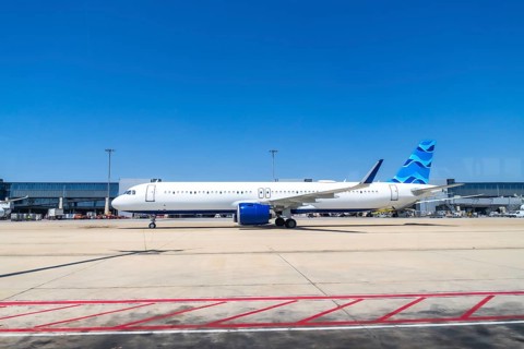 Modern passenger airplane parked on the tarmac at a bustling airport, preparing for its next flight