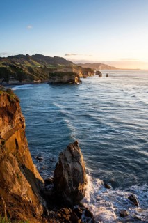The Three Sisters and Elephant Rock formations, sea, evening, golden hour. Taranaki Region, North