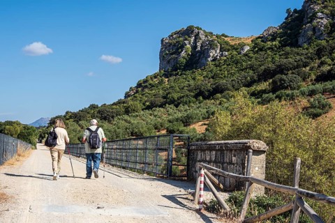 Hiking older couple, bridge Viaducto de Zaframagón, cycle path Via Verde de la Sierra, Puerto