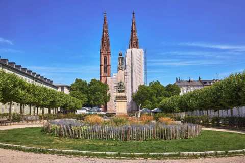 Park, round flower bed, plants, wooden fence, Waterloo monument, St. Boniface Catholic Church,