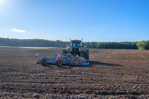 Field treatment of the agricultural cooperative with a large tractor with harrow, Othenstorf,