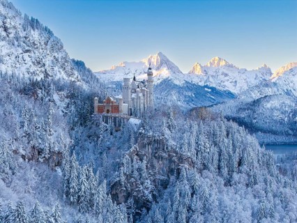 Majestic Neuschwanstein Castle surrounded by snow-covered Alps and thick forests, a winter dream,