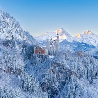 The enchanting Neuschwanstein Castle in a symmetrical, snowy mountain landscape, Schwangau near