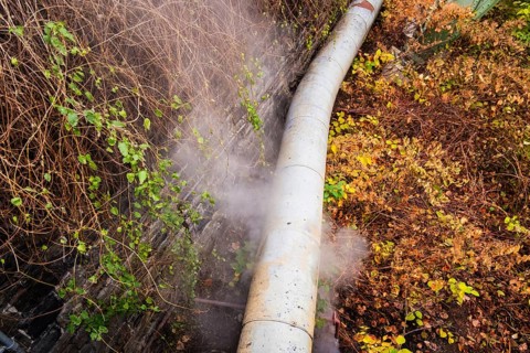 District heating pipeline in front of old industrial buildings on the banks of the Wupper,