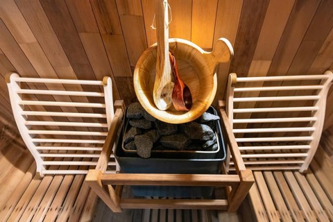 Steam and hot stone wooden cedar compact sauna interior with heating stone electrical device, hot