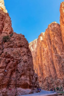 Narrow gorge with high, red-illuminated rocks under a clear sky, Todra Gorge in Morocco