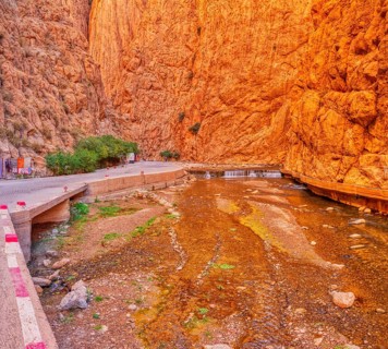 Impressive gorge with orange cliffs and a watercourse in the middle, Todra Gorge in Morocco