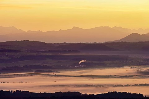 View from Horben of the Reuss Valley covered in fog, behind it the Glarus Alps in the light of the