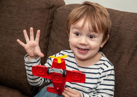 Little boy with gestures, 3 years old, playing with airplane indoors in Ystad, Skåne County,