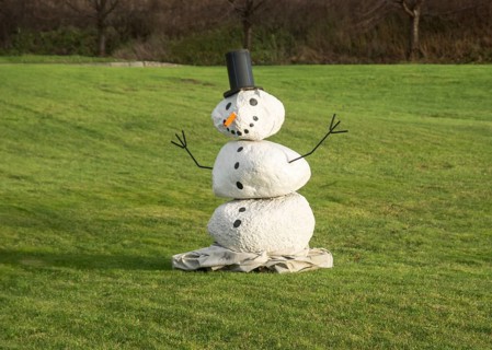 Snowman on green lawn at green winter in Ystad, Skåne County, Sweden, Scandinavia