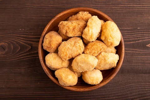Fried crispy Chicken Nuggets on brown wooden background. top view, flat lay, copy space