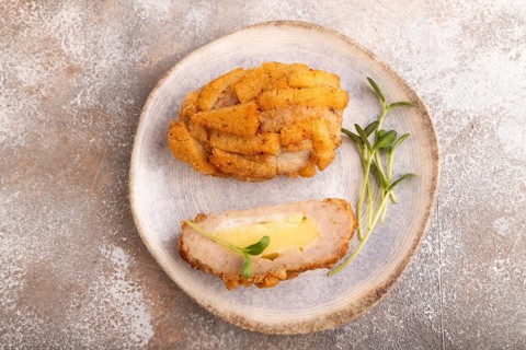 Chicken schnitzel on blue plate with microgreen on brown concrete. Diet, healthy eating. top view,