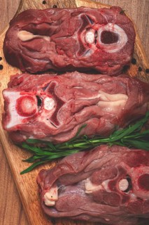 Raw steak, calf's neck on the bone, fresh meat, on the cutting board, top view, no people