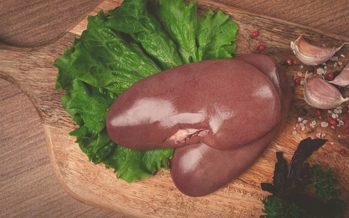 Raw pork kidneys, on a chopping board, close-up, top view, no people