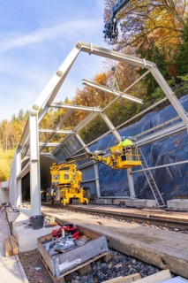Construction work at a tunnel entrance in autumn with yellow construction equipment and visible
