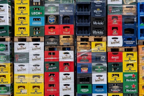 Empty beverage crates, from various manufacturers, bottling, types, stacked at a restaurant, for